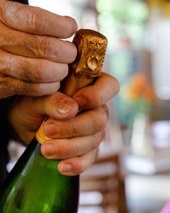 Mann öffnet Sektflasche