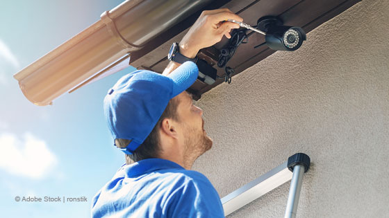 Mann installiert Überwachungskamera