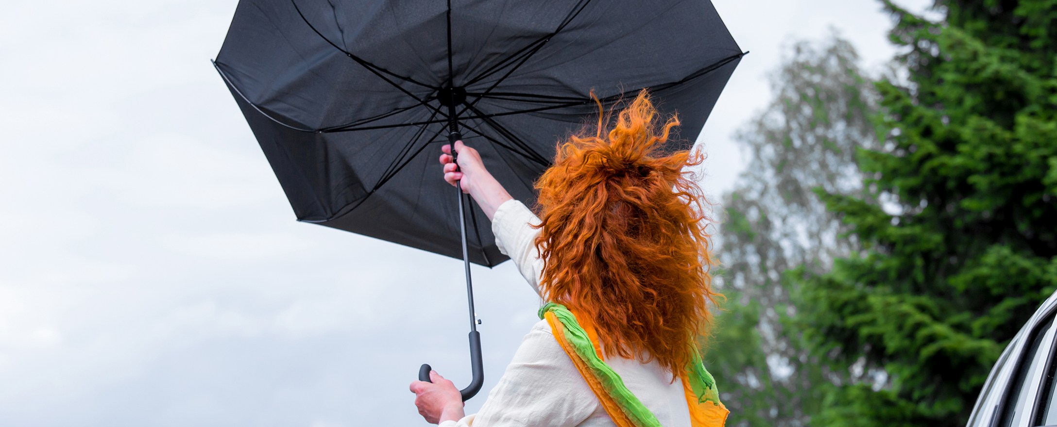 Frau mit Regenschirm im Sturm