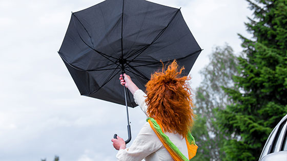 Frau mit umgedrehten Regenschirm im Sturm